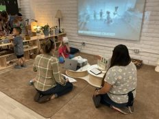 Two adults and two children watching a video of a child reenactment of the book A Line in the Sand.