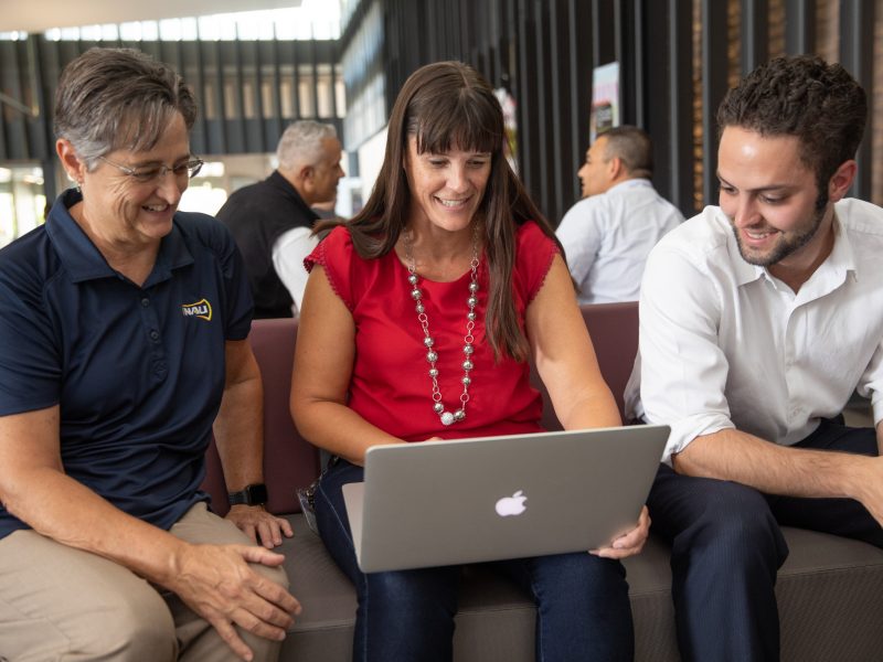 NAU staff members gathering around a laptop.