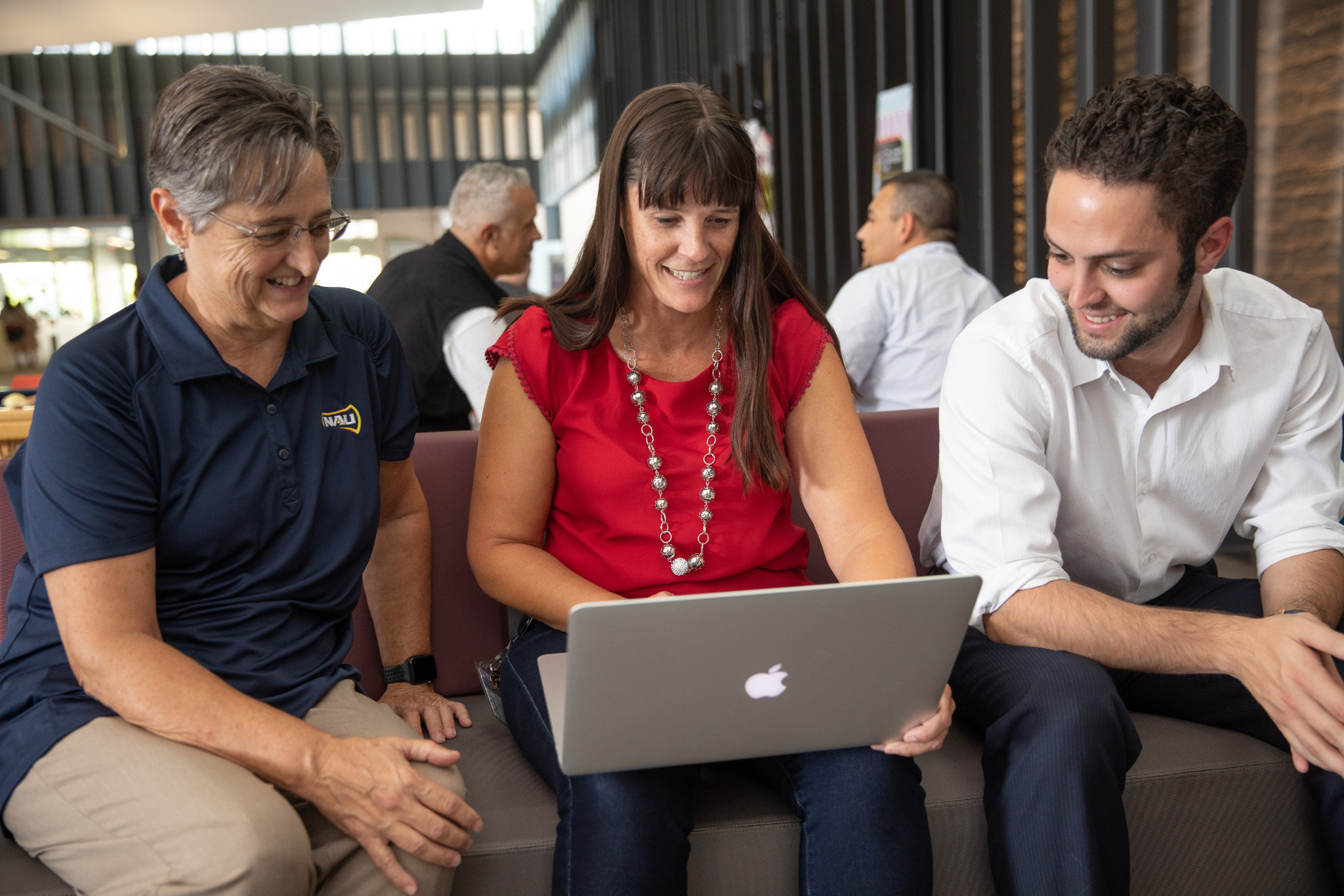 NAU staff members gathering around a laptop.