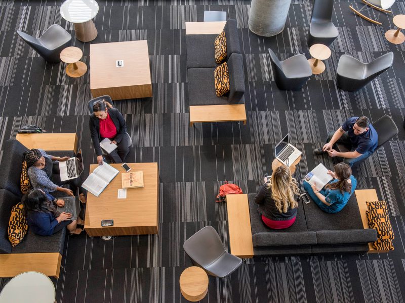 Top-down view of two groups of people sitting at tables.
