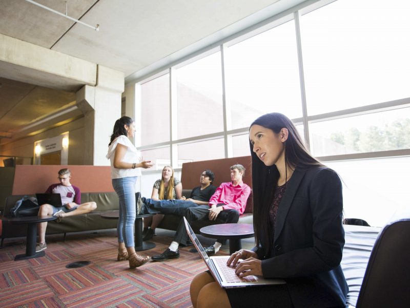 Student sitting in lounge looking off to the distance.