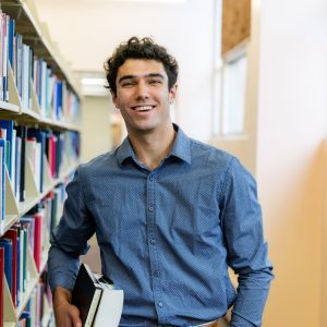 Ethan Ward holding books in the library.