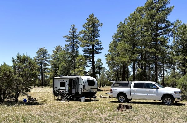 A parked truck with a camper attached to it in a camping area of the NAU Hat Ranch.