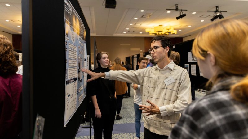 Students standing in front of a display having a discussion.