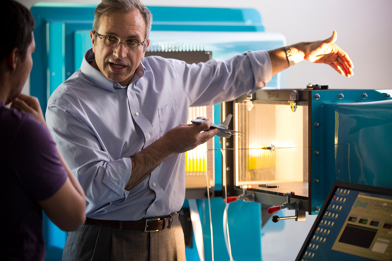Engineering professor shows student how machine works..