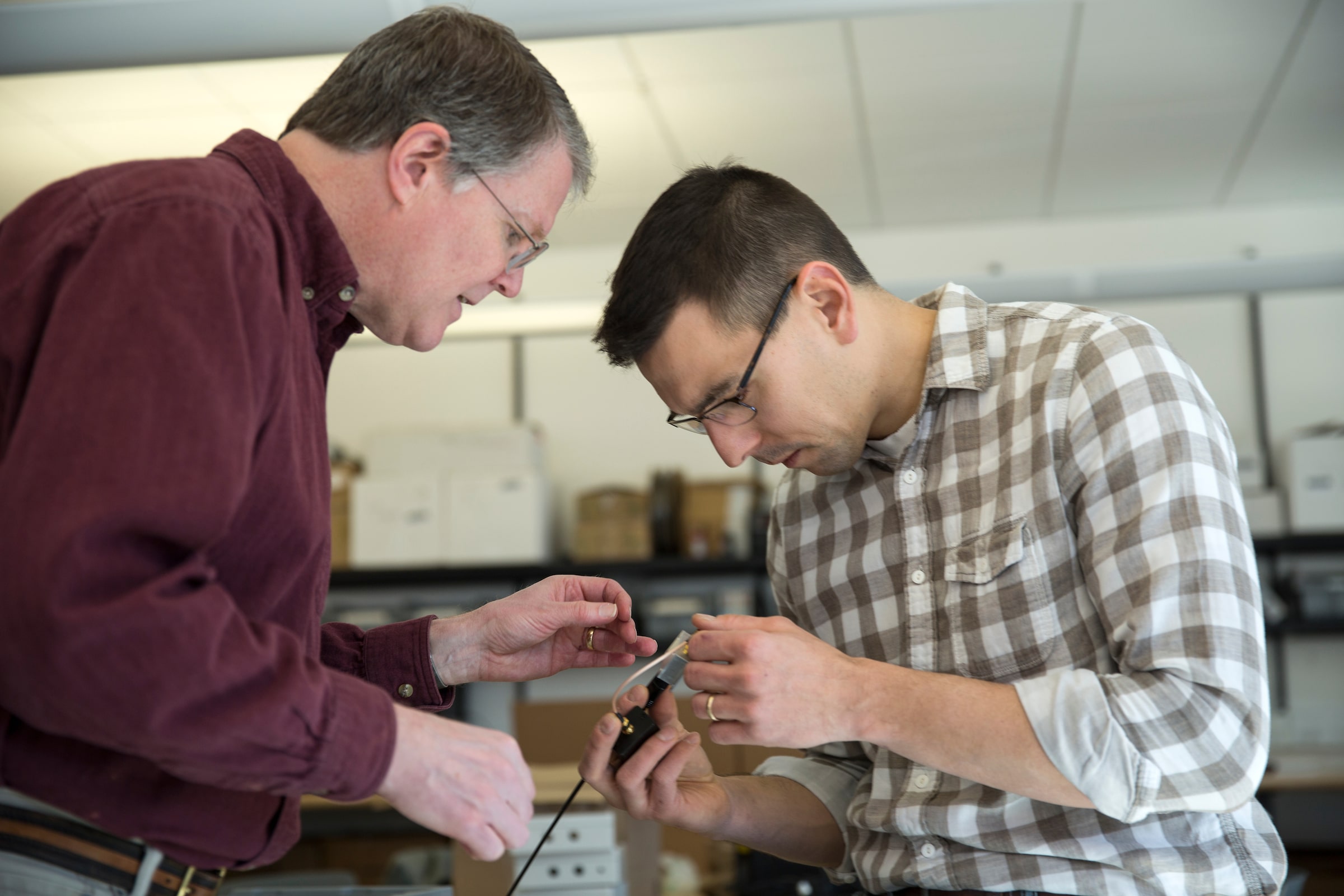 Professor and student looking at tool together.