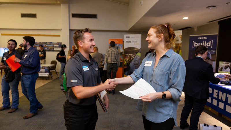 Two people shaking hands at Construction Management Career Fair.