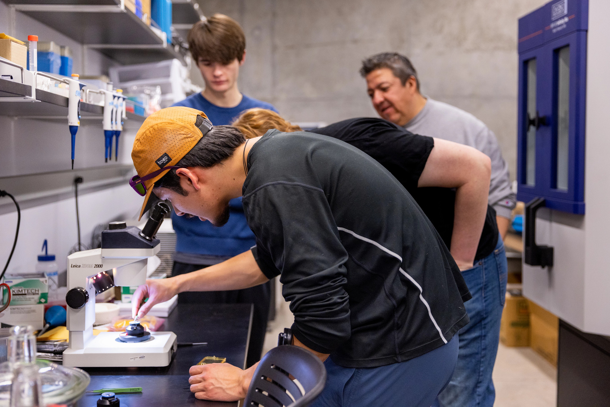 Students working on a nano imaging lab under a microscope.