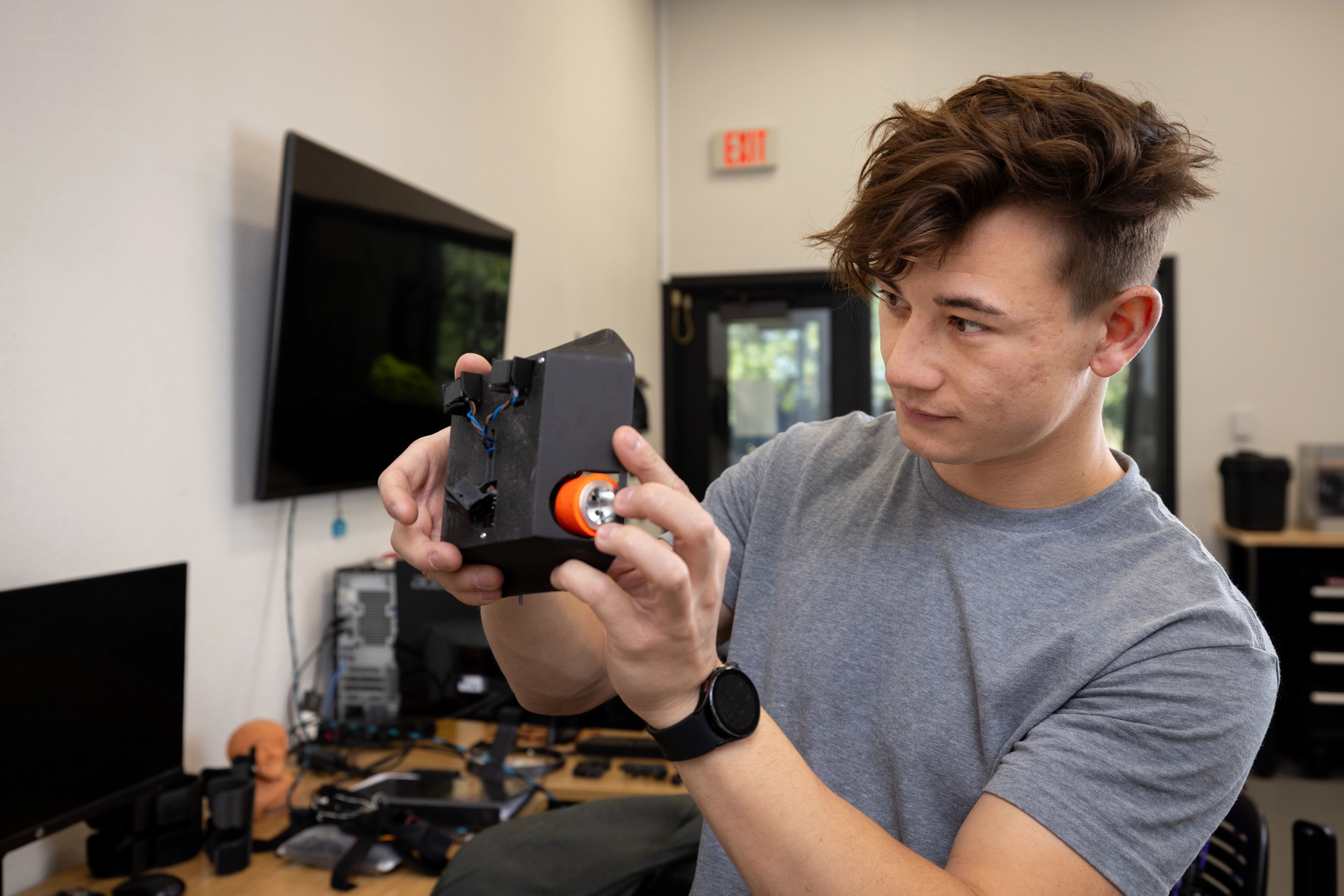 A student evaluating a computer component in a lab.