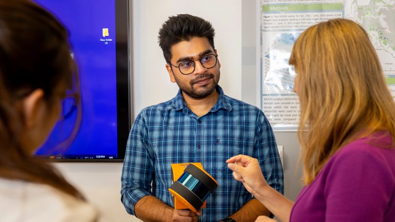 Instructor explaining how a piece of equipment works to a student.