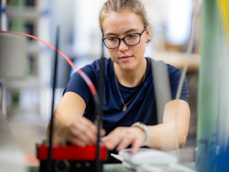 N A U student working on wiring a device.
