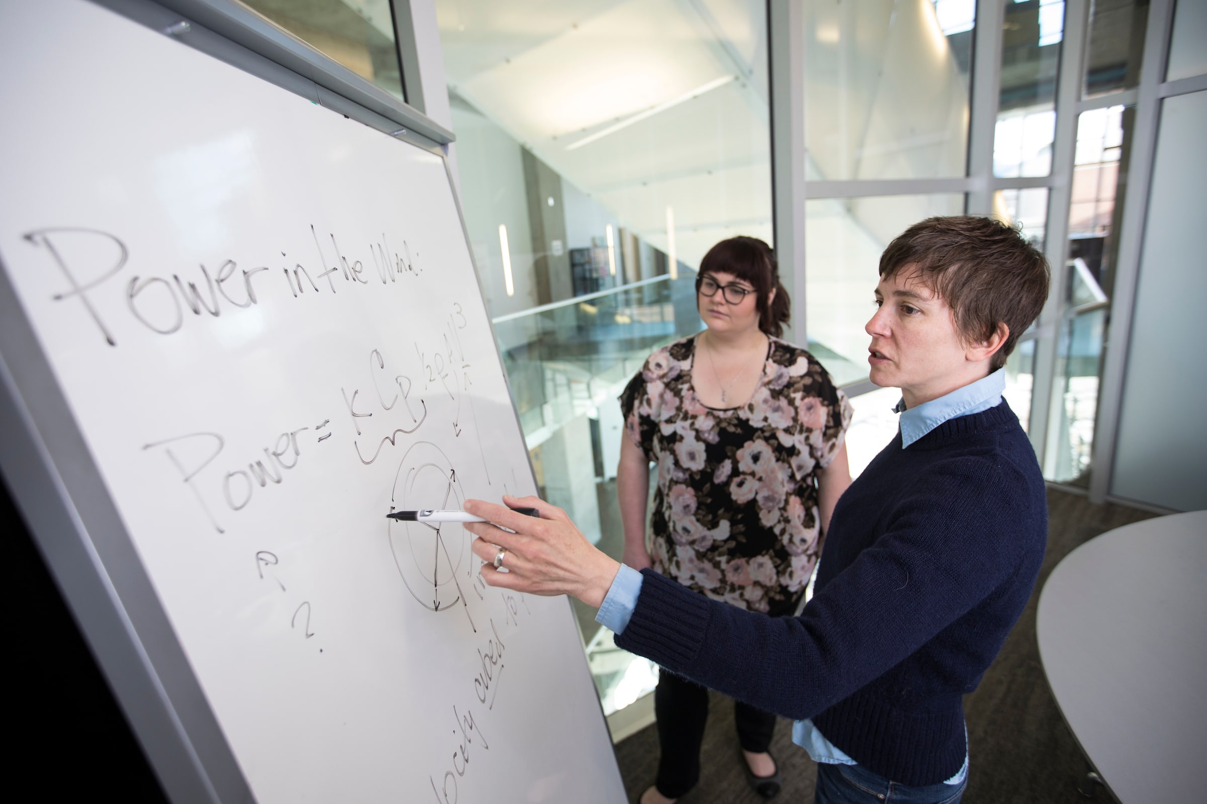 Professor and student working together at whiteboard.