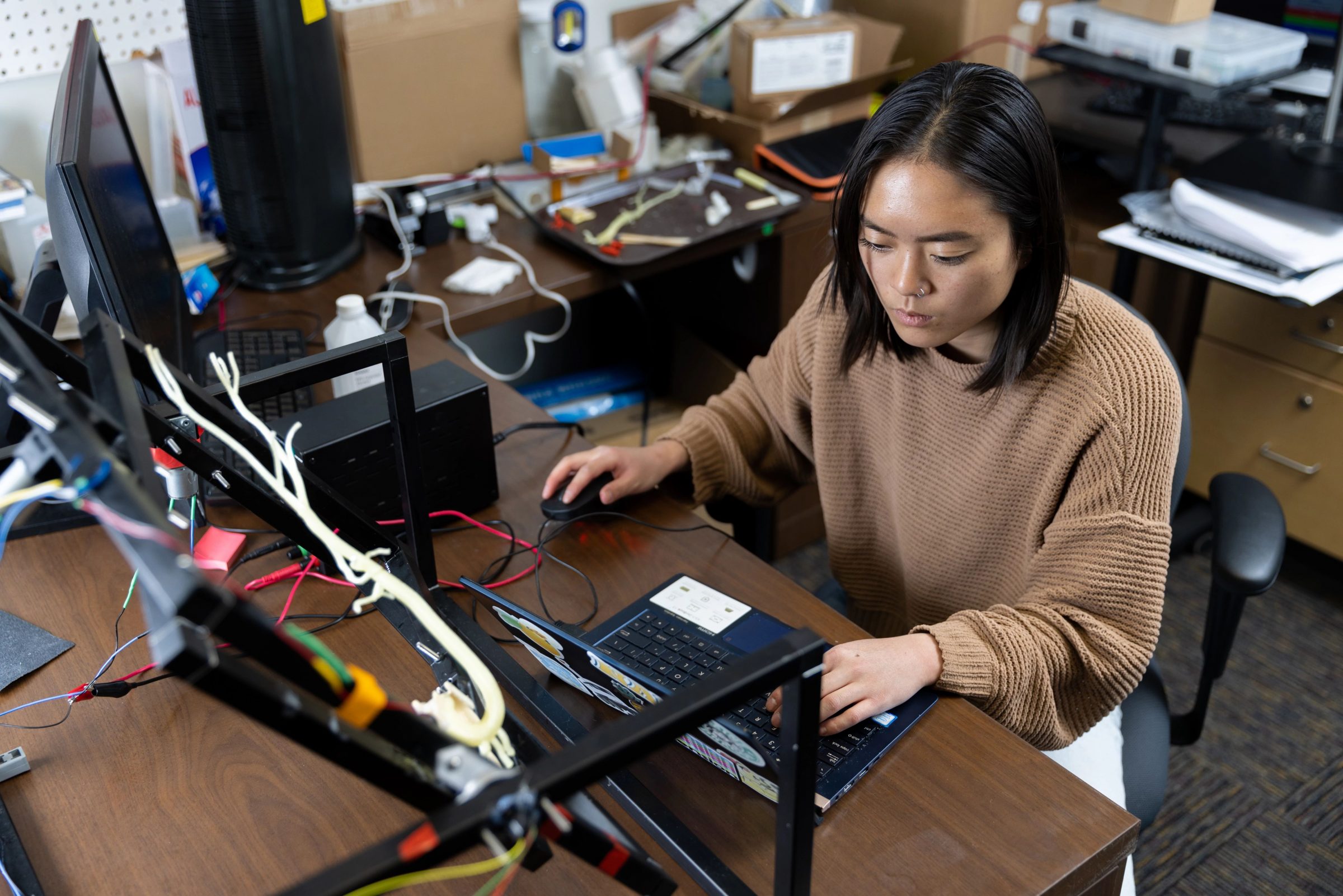 Anna Mellin sitting at a desk and working on laptop.