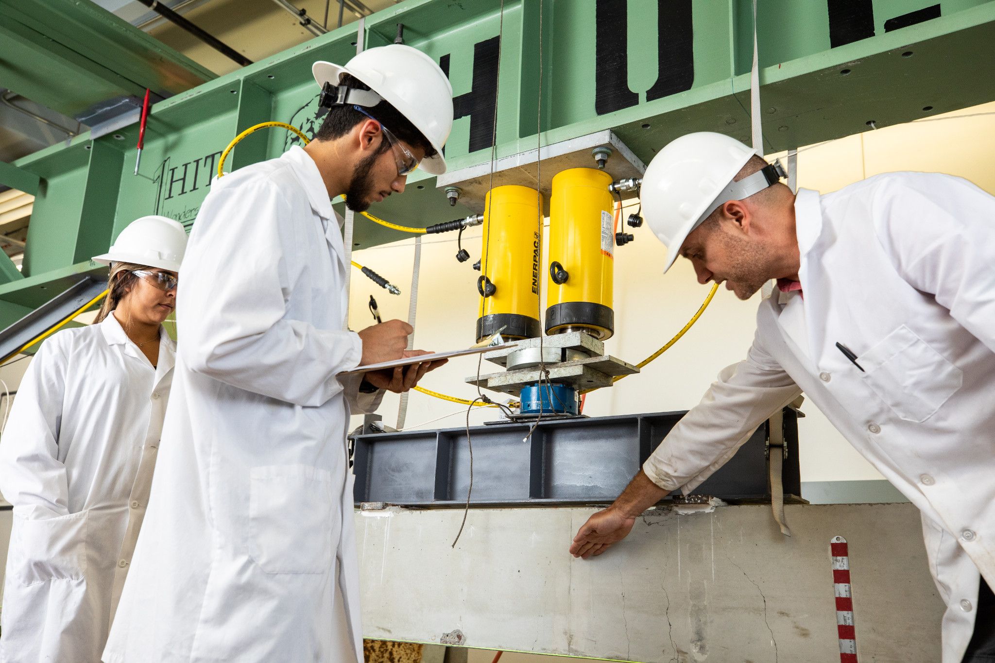 Students taking notes while listening to an instructor explain a mechanism.