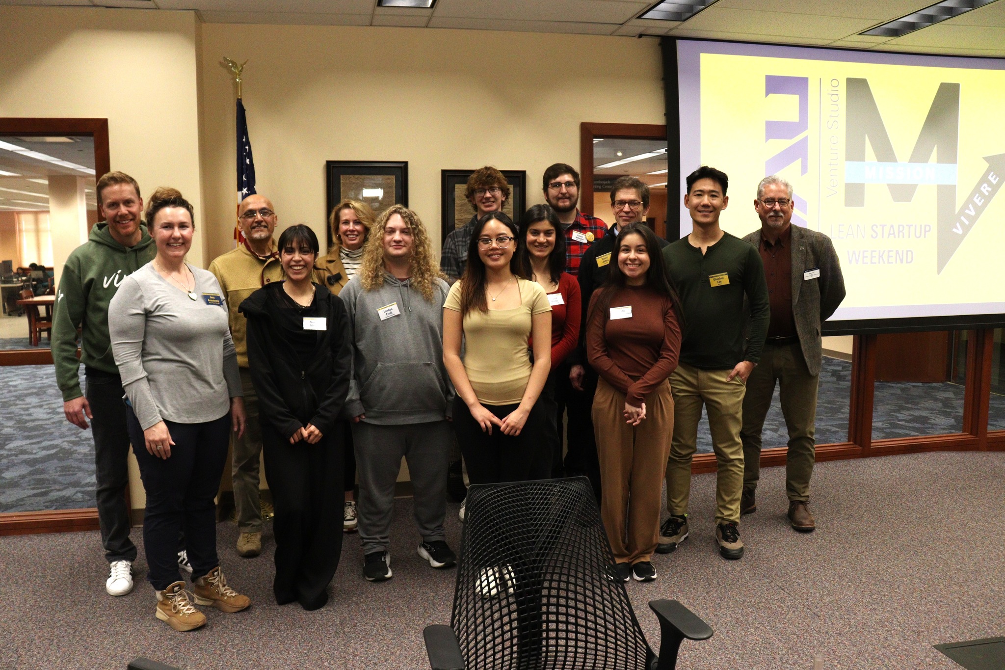 A group of people stands in front of NAU Venture Studio