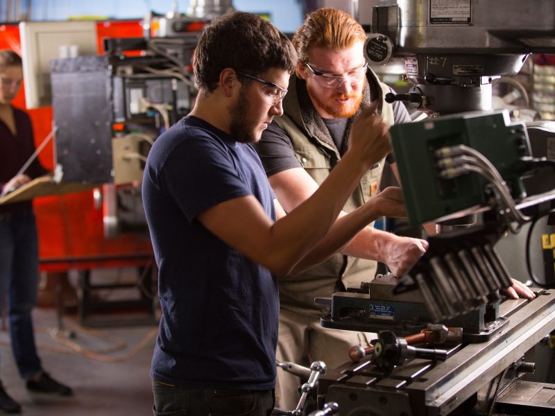 N A U engineering students working with machinery.