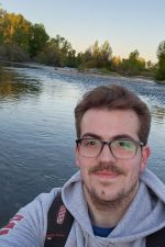 Brice Liedtke smiling in front of a lake.