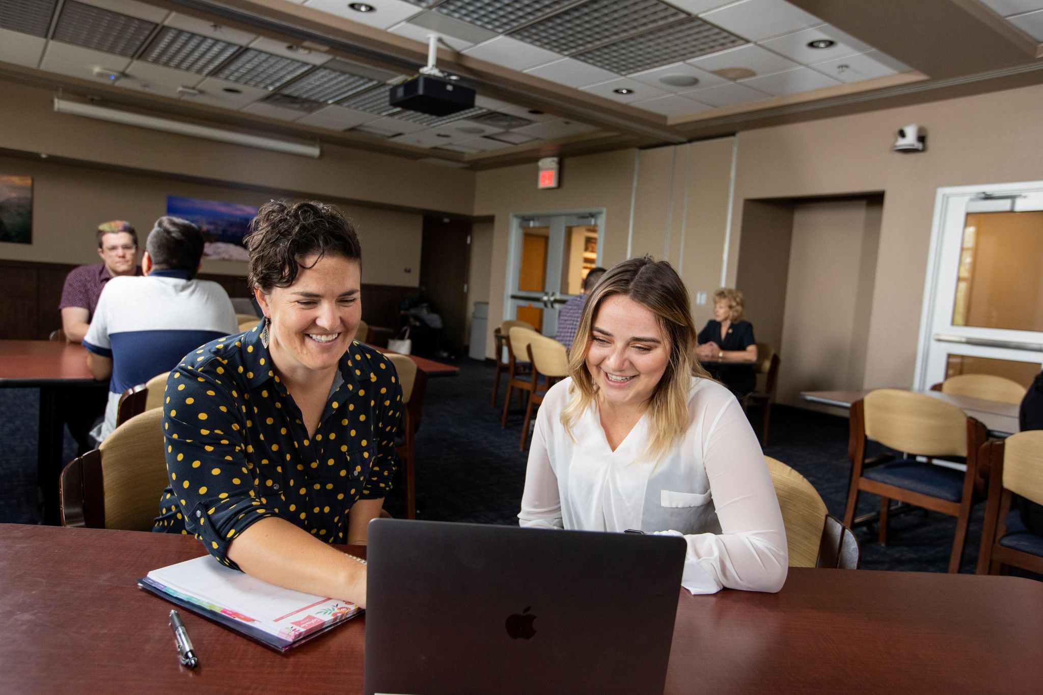 Alumni sitting down at a laptop with a networking representative.
