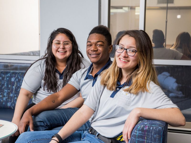 Students sitting together and smiling.