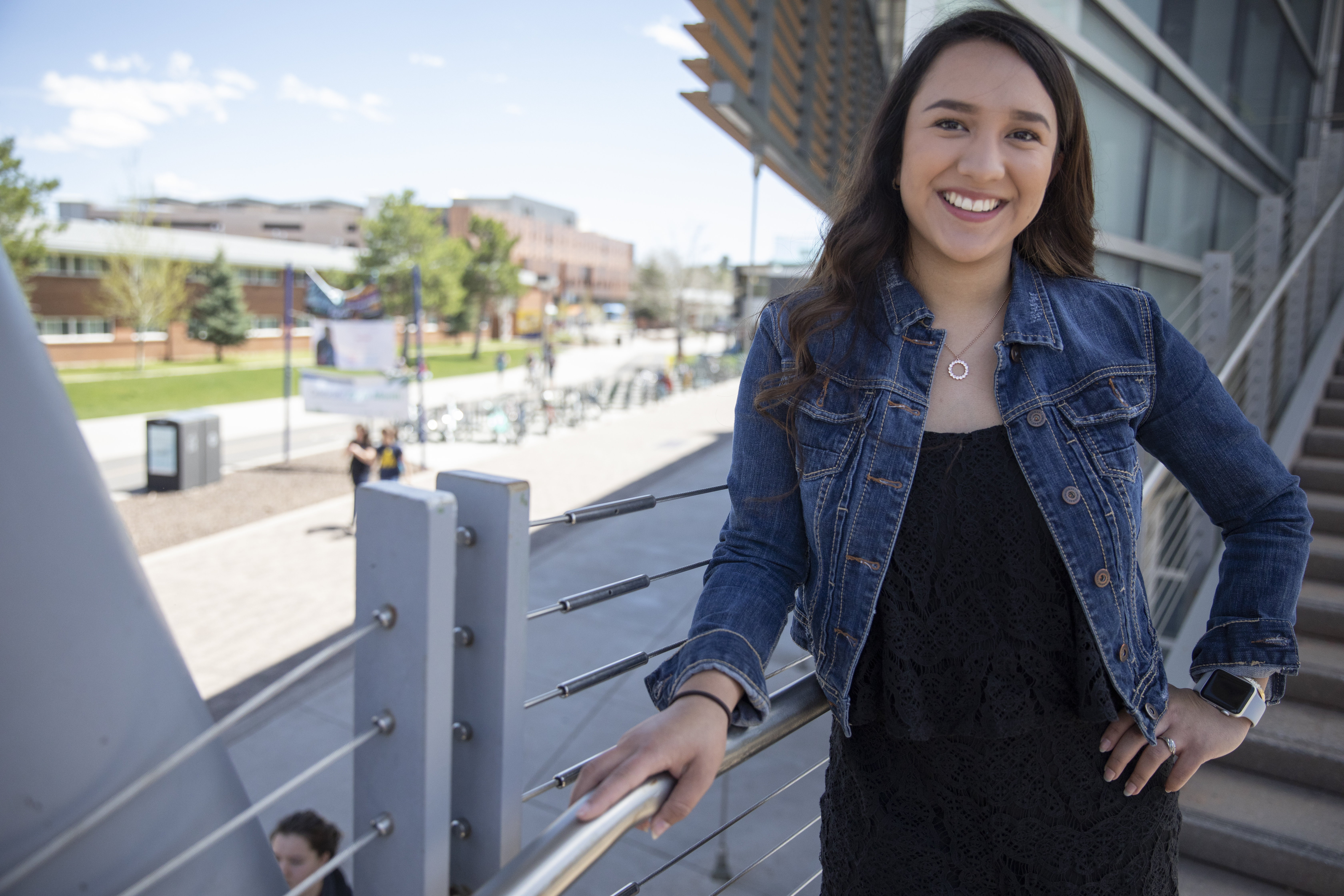 N A U student leaning on railing while posing for camera.