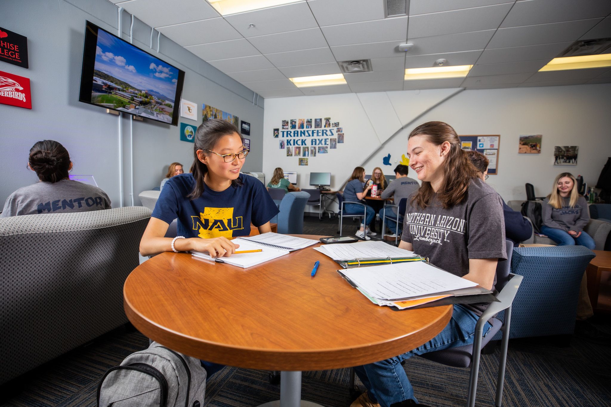 Two students sitting together at a table working on homework.