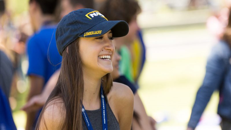 A photo of a new student smiling and wearing N A U gear.