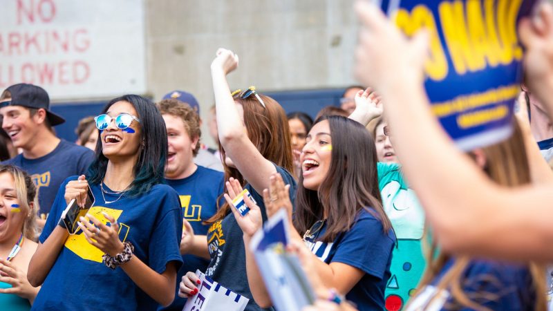 Students wearing NAU blue and gold cheer at a Welcome Week event