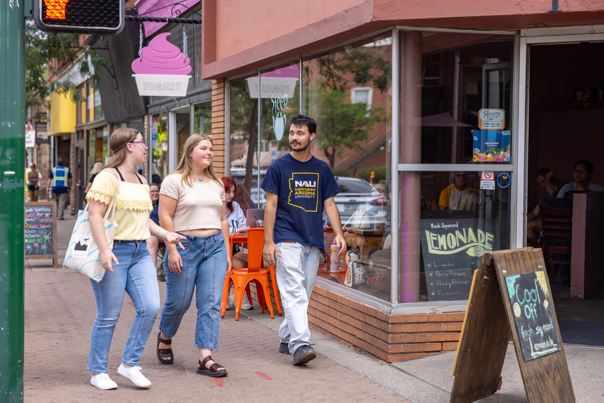 Three students walking in front of Yogaert in downtown Flagstaff