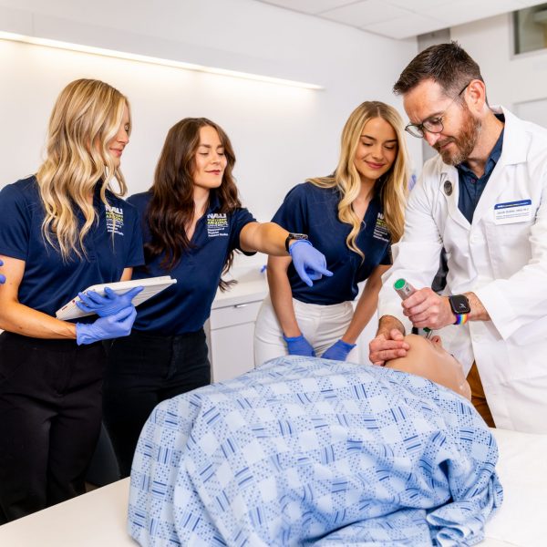Medical students in a lab practicing with medical equipment