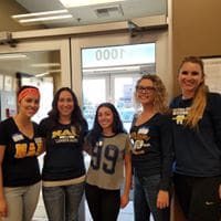 Five alumni women standing in front of a door.
