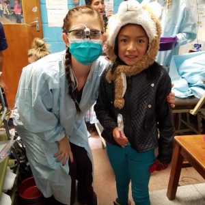 A dental hygienists smiling with a child.
