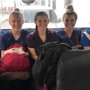 Five dental hygienists sitting in the back of a van.