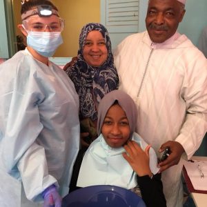 A dental hygienists with a patient and her family.