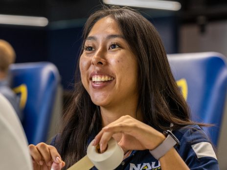 A student taping a patient's hand.