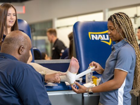 A student tapes another student's foot