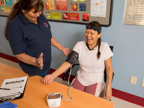 A health student taking a women's blood pressure.