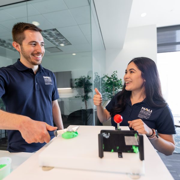 Click on image to be directed to disability services. A male occupational therapy student smiles as his female peer gives him a thumbs up.