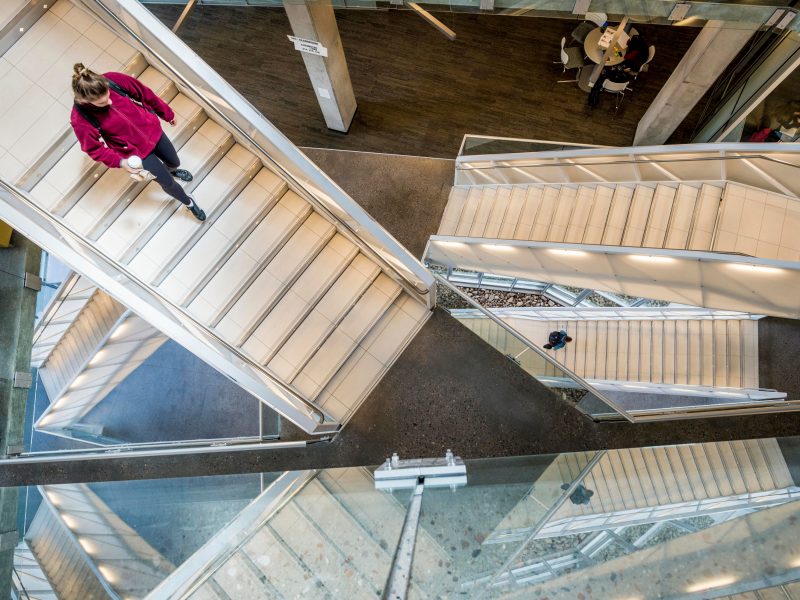 A student walks down a winding set of stairs.