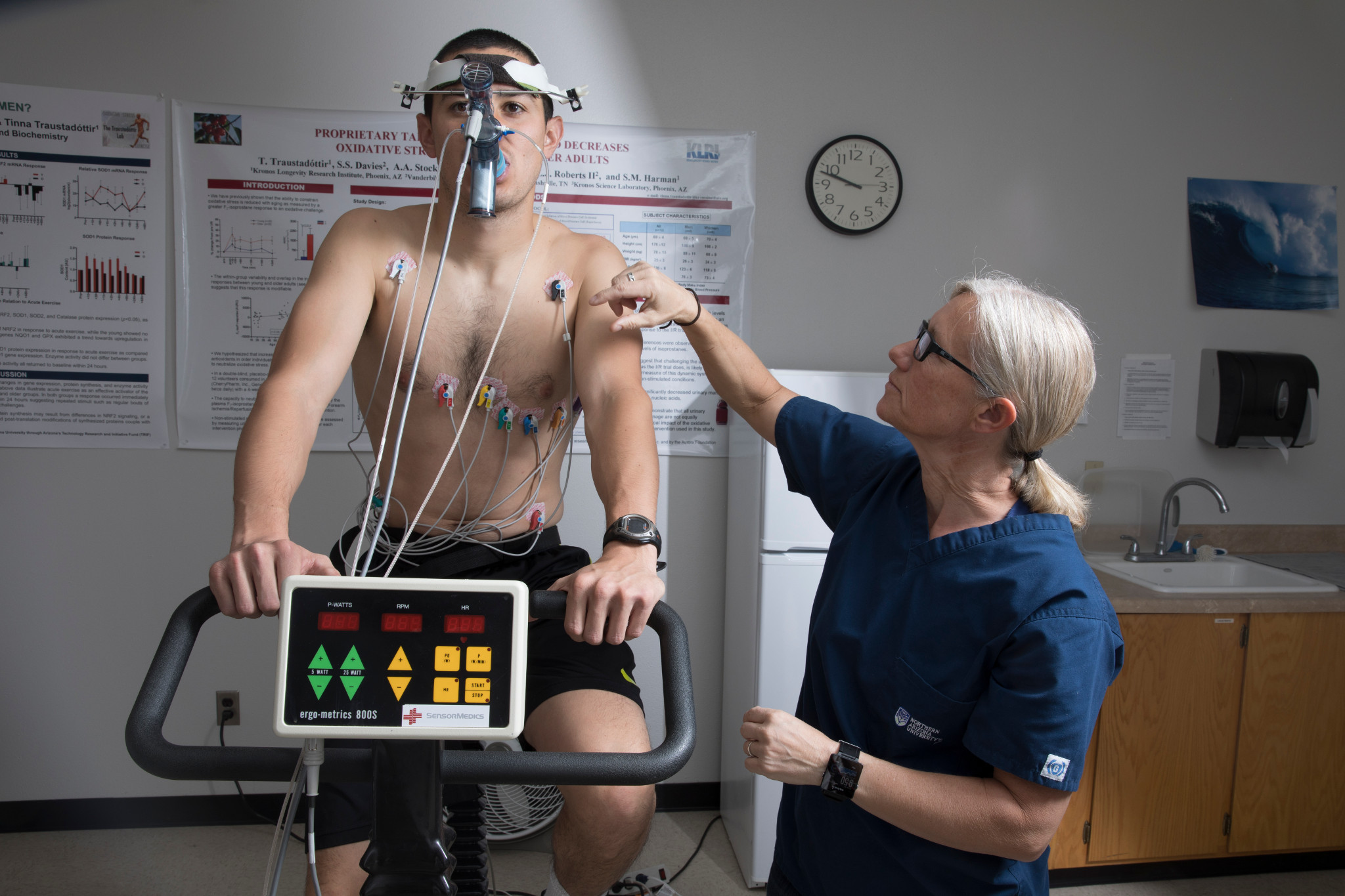 Person on exercise bike attached to monitors for testing.
