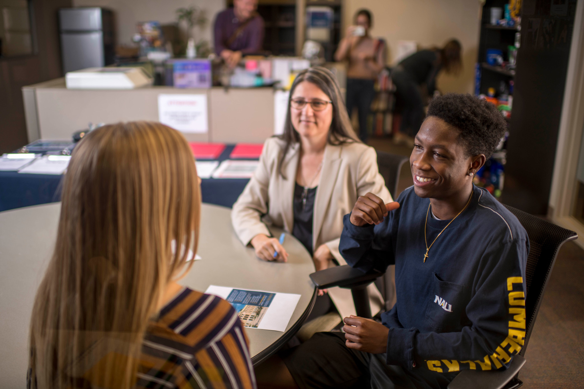 Students conversing at a desk in an N A U classroom.