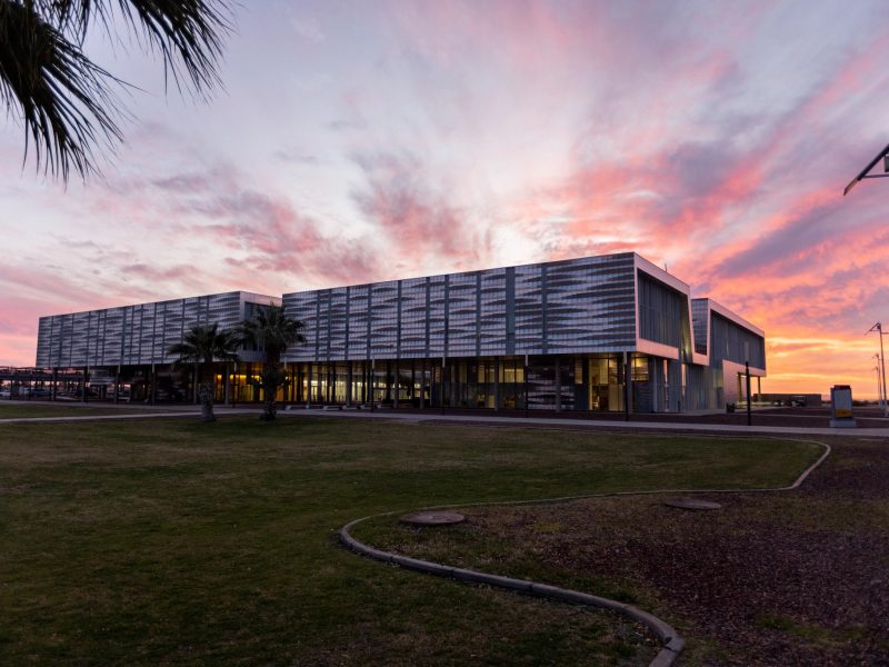 Campus building with a sunset in the background.