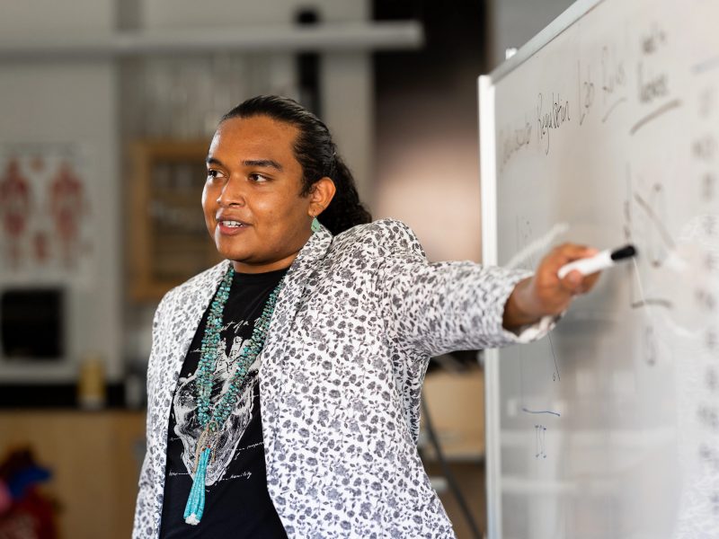 Student pointing at a white board.