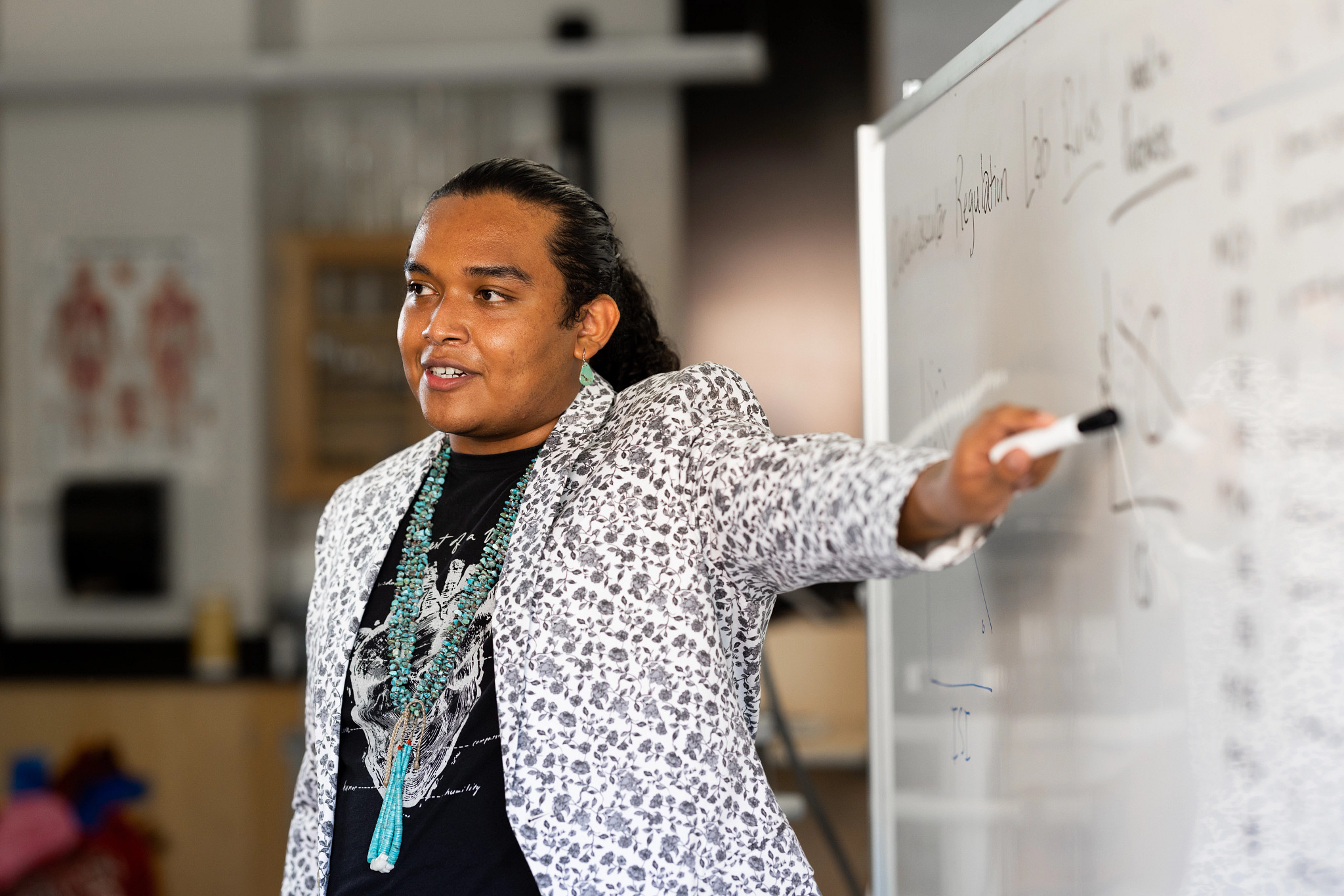 Student pointing at a white board.