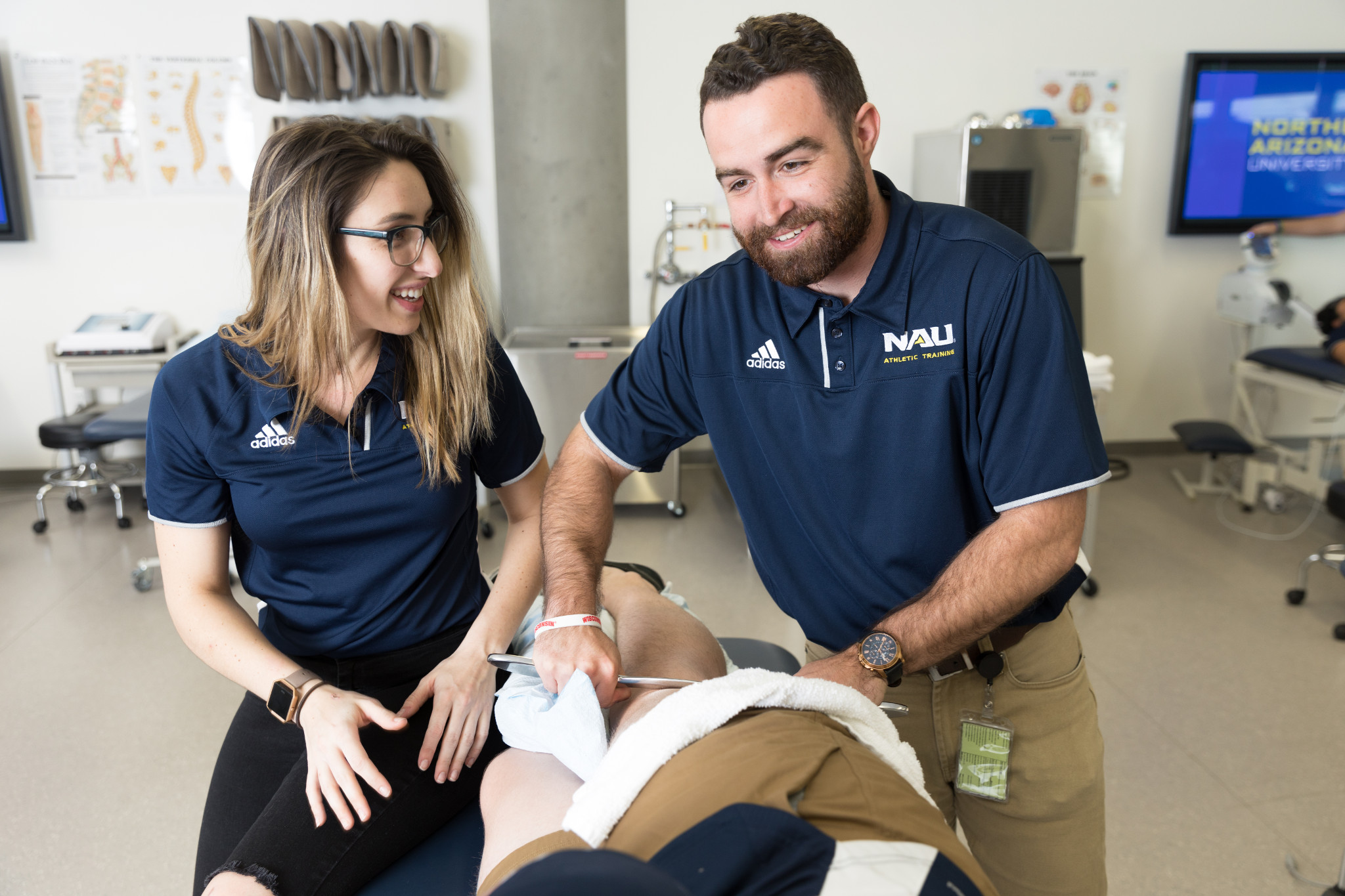 Two Athletic Training students practicing on another student.