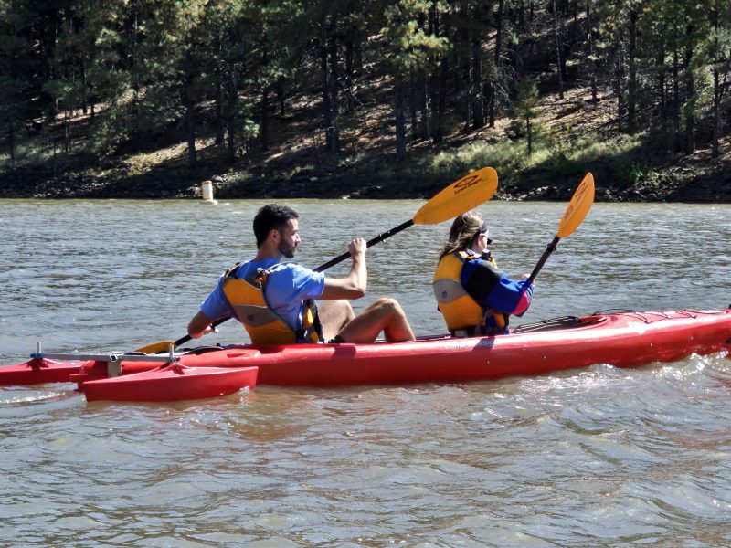A man and woman kayaking on a lake.