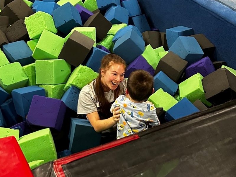 A person catching a child in a foam pit.