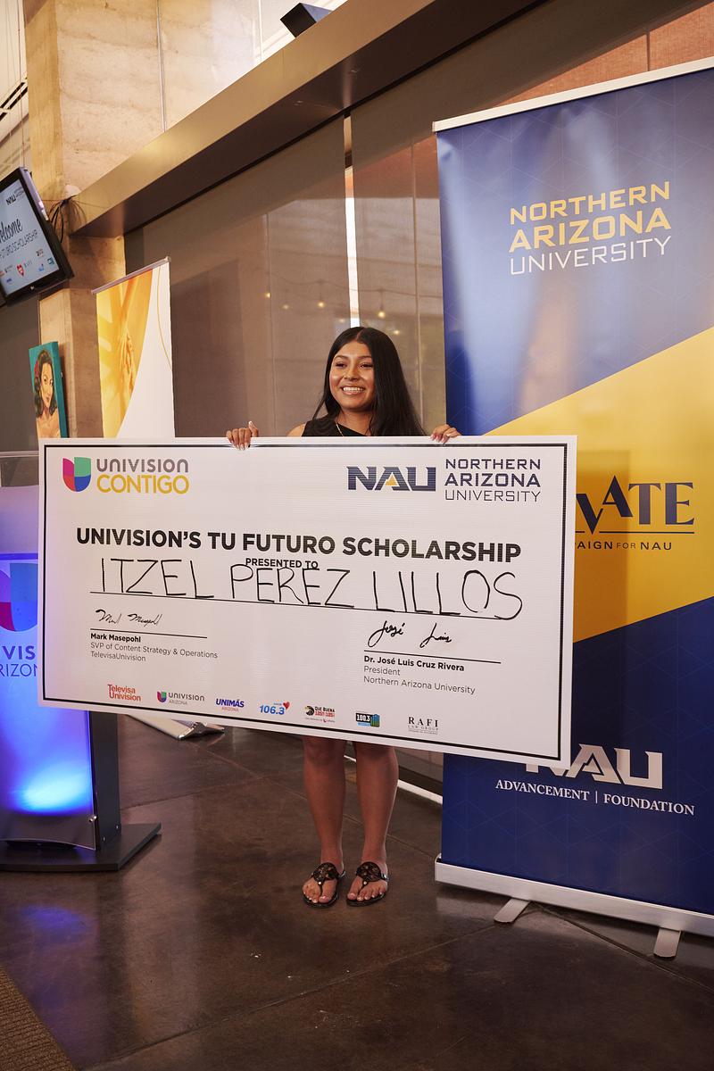 Mesa student wins full ride scholarship and holds check.