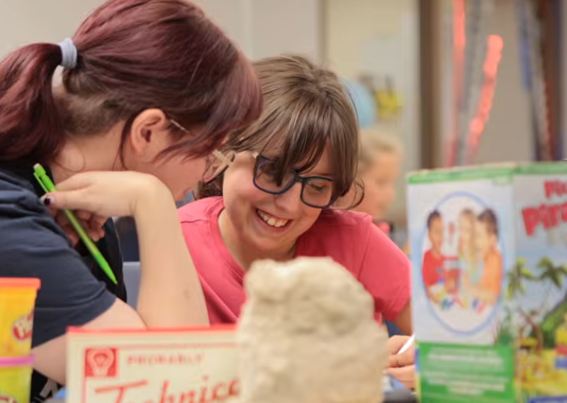 Grad student works with child at CSD camp.