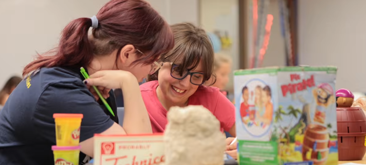 Grad student works with child at CSD camp.