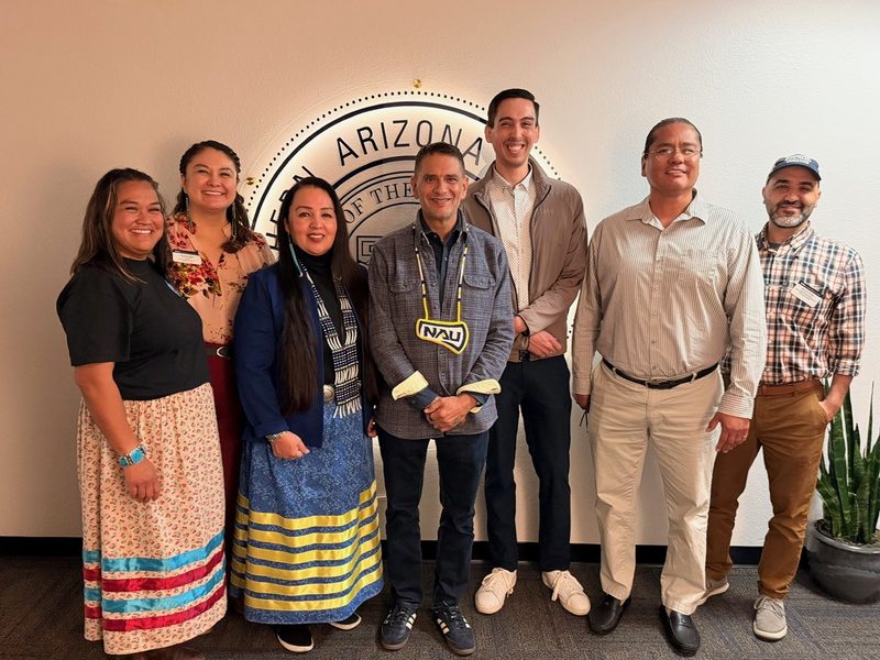 Skyler Benally-Bordeaux and staff/faculty pose for a picture with NAU President Rivera.